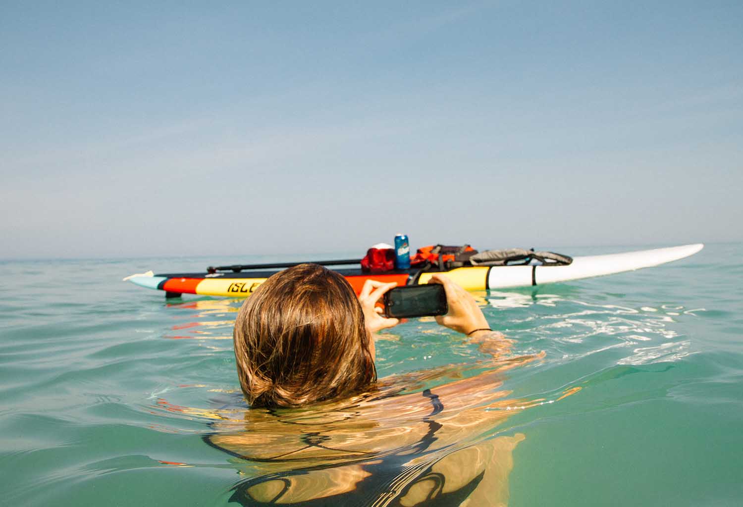 Woman using phone to take photo in sea